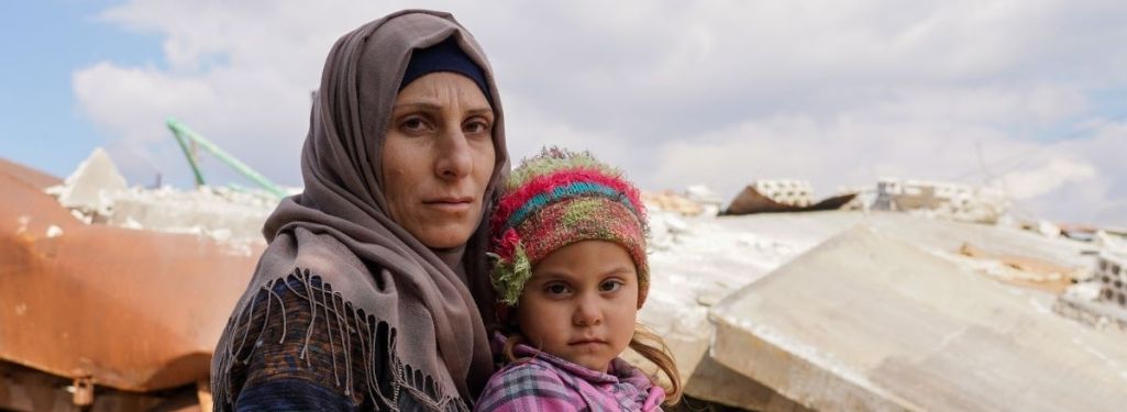 A mother holds her child on her lap in northern Syria.