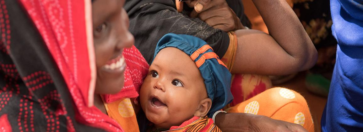 A young infant held by a caregiver in Ethiopia.