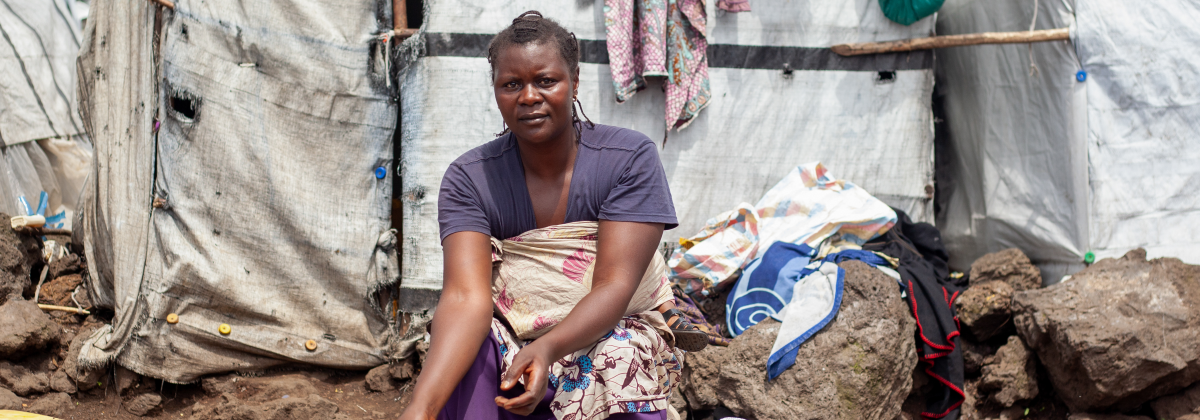 Woman sitting outside a shelter in DRC
