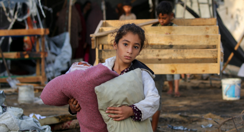 A child carries salvaged items following an Israeli air strike in Gaza. 