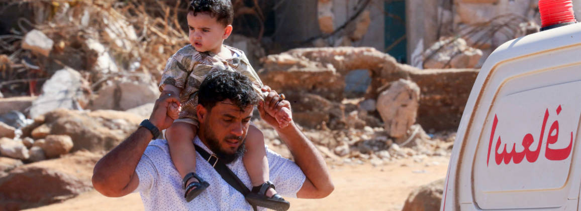 A child with his father in Libya after the flood