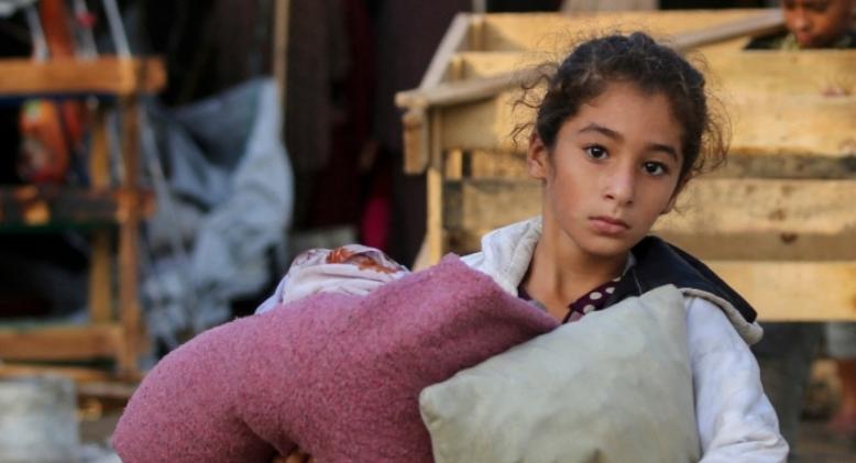 A child carries salvaged items following an Israeli air strike in Gaza. 