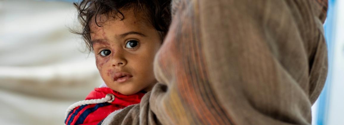 A woman holding her daughter whilst they visit an IRC clinic