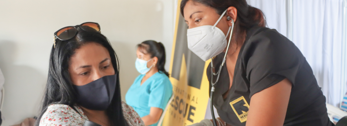 An IRC health worker examines a patient with a stethoscope at a medical consultation.