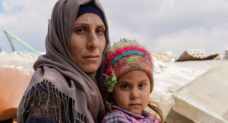 A mother holds her child on her lap in northern Syria.